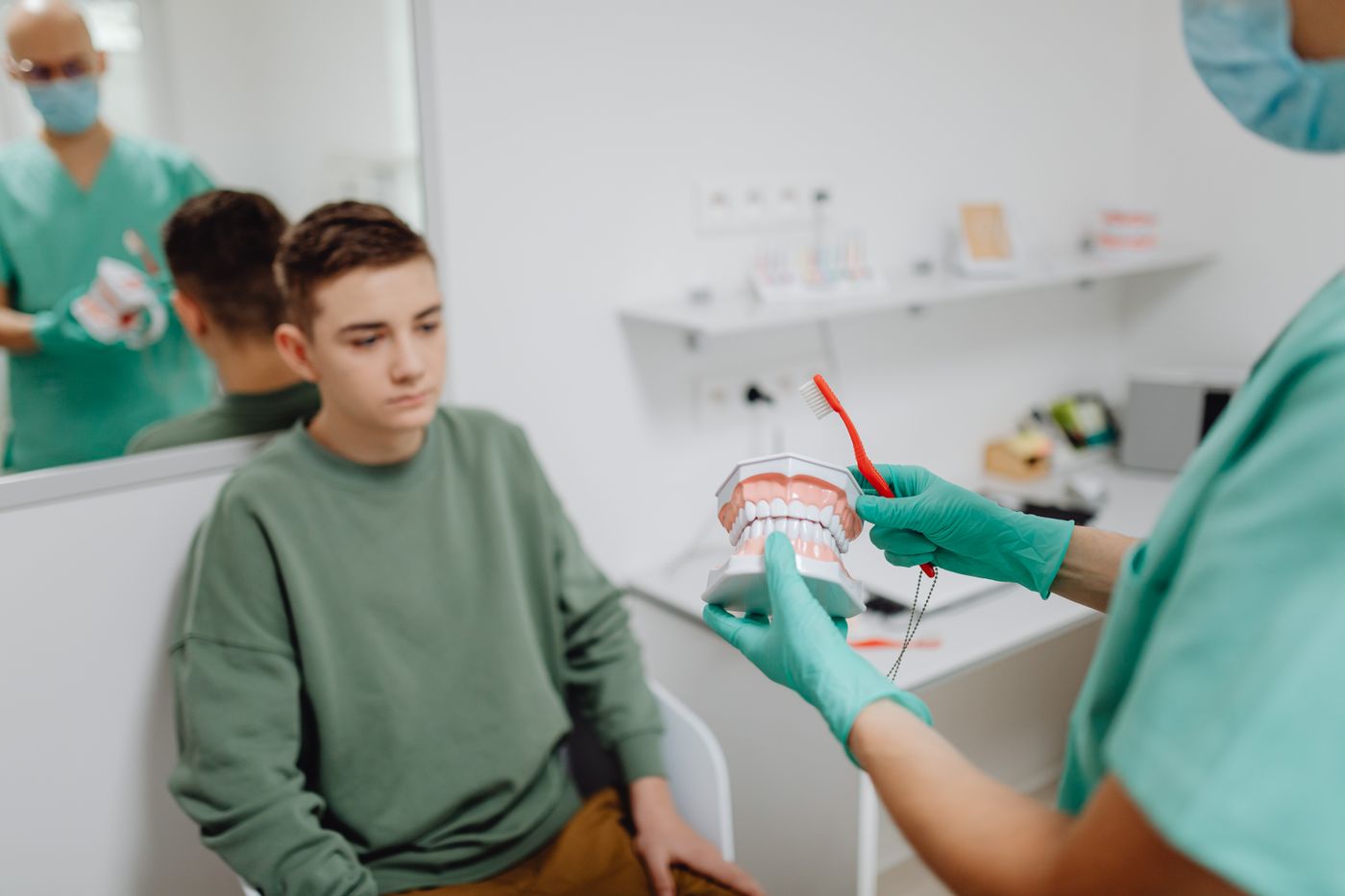 A clinician teaching oral health with a dental model